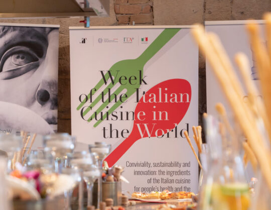 olasz ételek, plakát felirattal, előtte edények