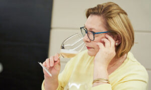 Mészáros Gabriella, szemüveges nő sárga fölsőben, kezében talpas pohár