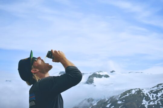 dobozos sör egy férfi kezében, hegyen, fényes nappal