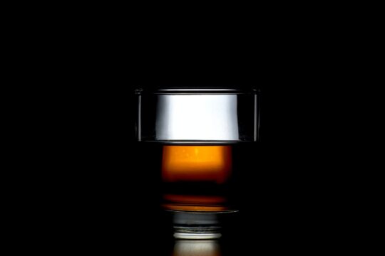 whisky átlátszó pohárban, fekete háttér előtt