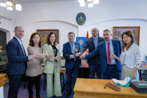 tokaj, emberek állnak egy helyiségben, pohárral koccintanak
