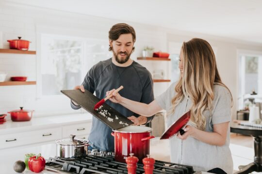 férfi és nő főz konyhában, előttük piros edény