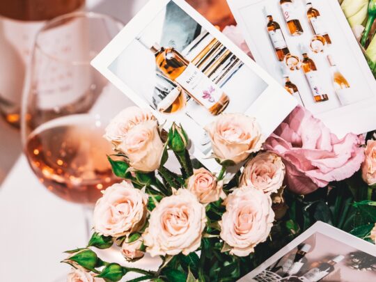 egy pohár rozé, mellett rózsák és fotók