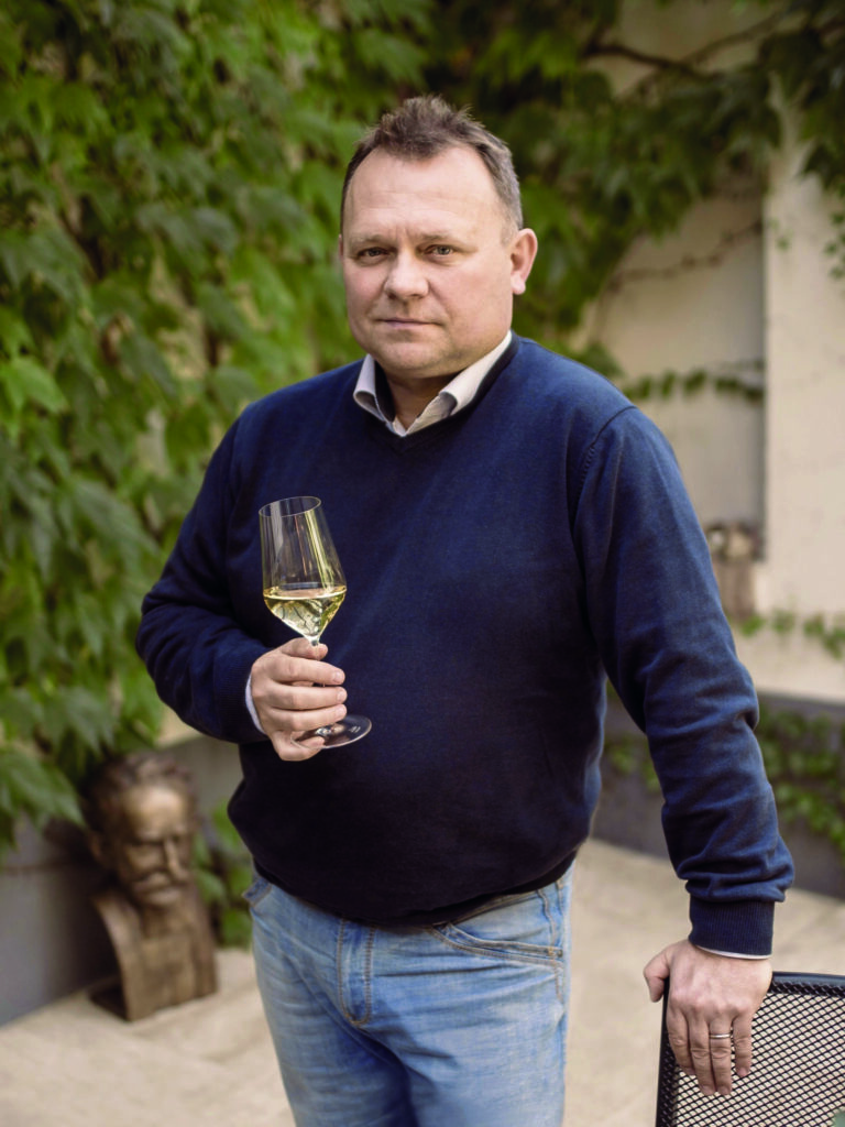 férfi áll kezében egy pohár bor