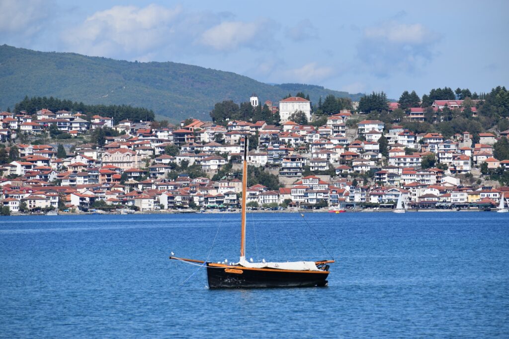 észak-macedónia kék tava, rajta egy csónak, háttérben házak