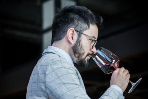 szakállas, szemüveges férfi poharat tart a szájához