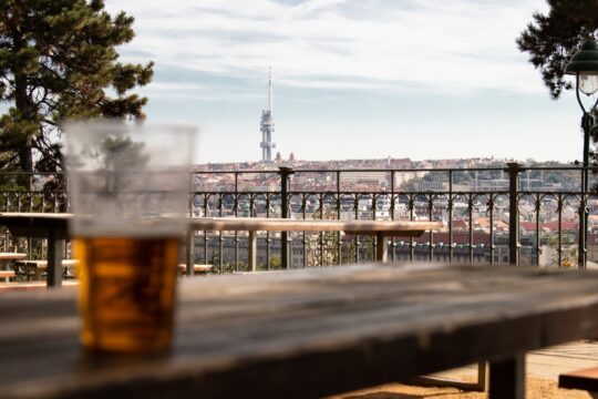 pohár sör az asztalon, mögötte épületek