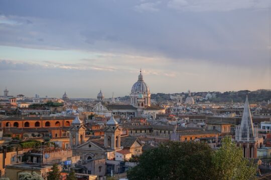 róma látképe nappal, kőépületek, templomok, kék ég