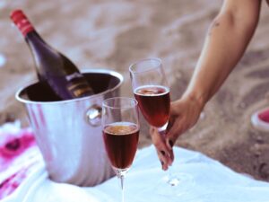 palack és két pohár a homokban