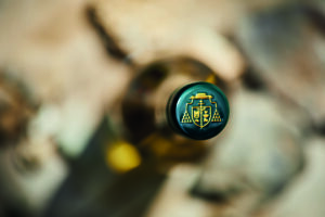 zöld borosüveg, zöld kupak, rajta a Veszprémi Érseki Pincészet logója