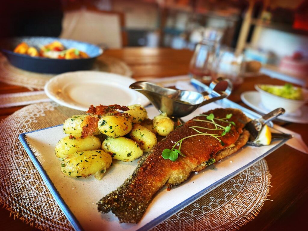 barna hal és sárga krumpli fehér tányéron