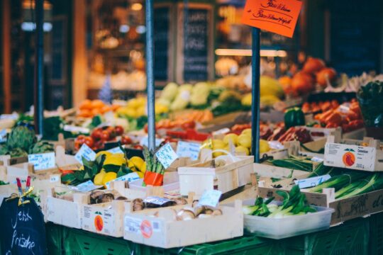 egy piac standja, színes zöldség és gyümölcs a standon