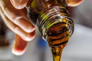 barna olívaolaj folyik egy üvegből