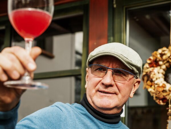 ember piros színű bort tart a magasba