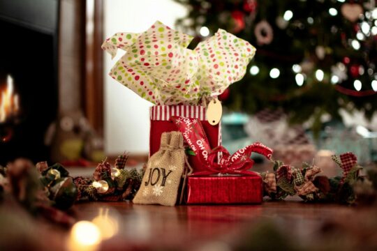 ajándékok és díszek, háttérben karácsonyfa