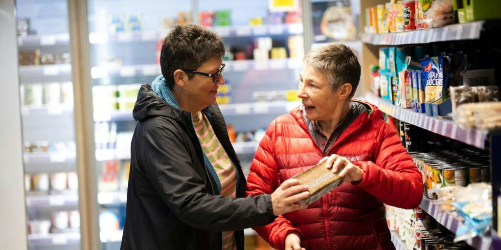 két nő áll a supermarket polcai között