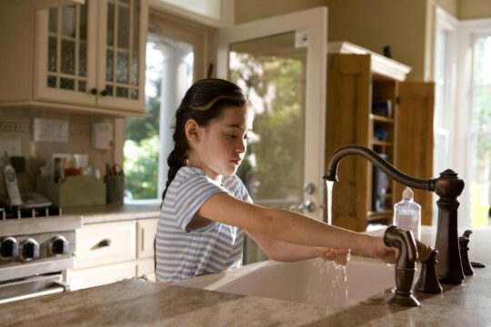 kislány mossa a kezét a konyhában
