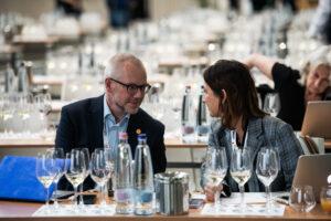 egy férfi meg egy nő ülnek egy asztalnál, asztalon üvegek