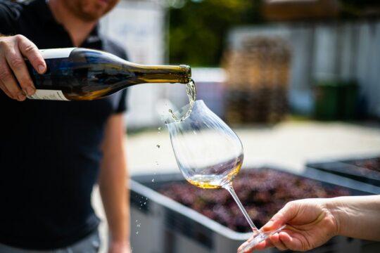 palackból pohárba töltenek bort