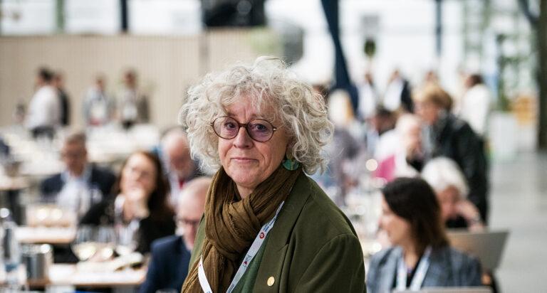 szemüveges nő néz a kamerába