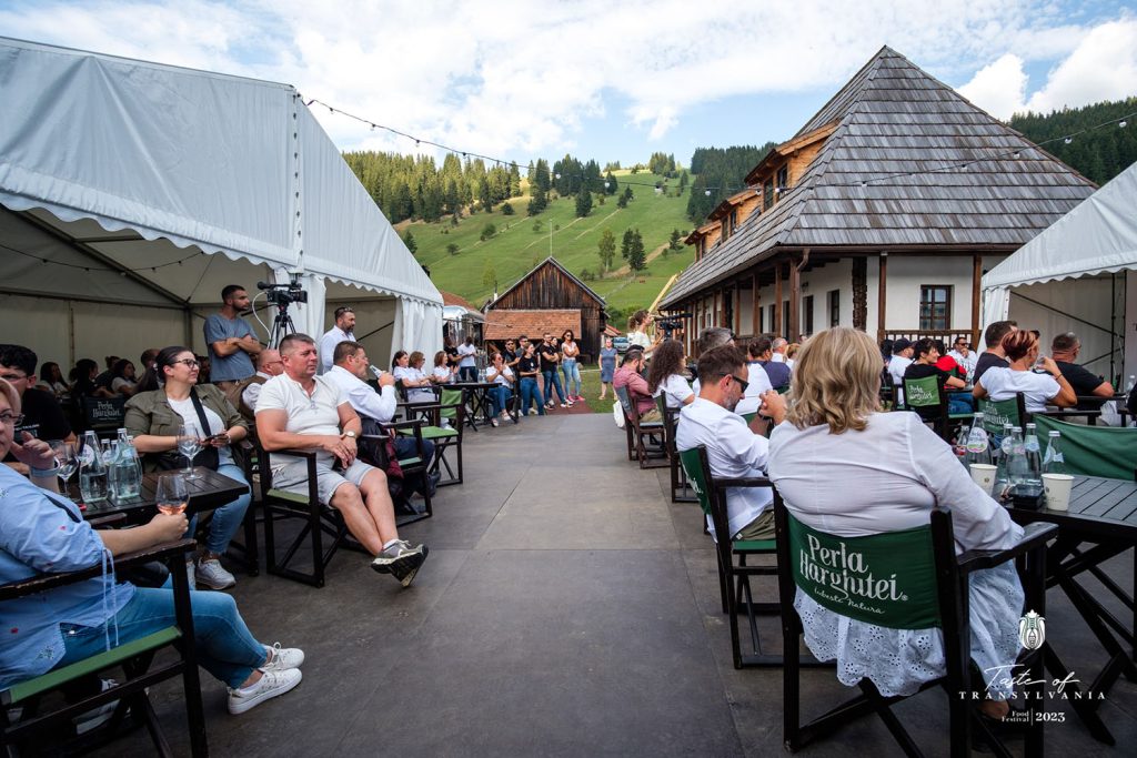 Taste of Transylvania, emberek ülnek egy udvaron, körülöttük házak