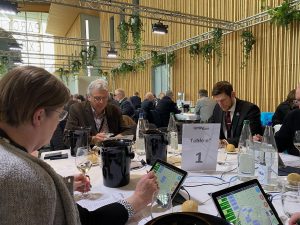 emberek ülnek asztalnál, bort kóstolnak, borverseny